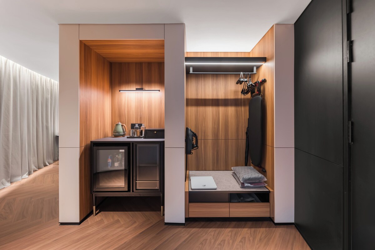 Une petite pièce comprenant un coin cuisine, un lit et une armoire.