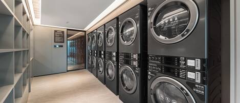Una sala de lavandería con varias lavadoras alineadas.