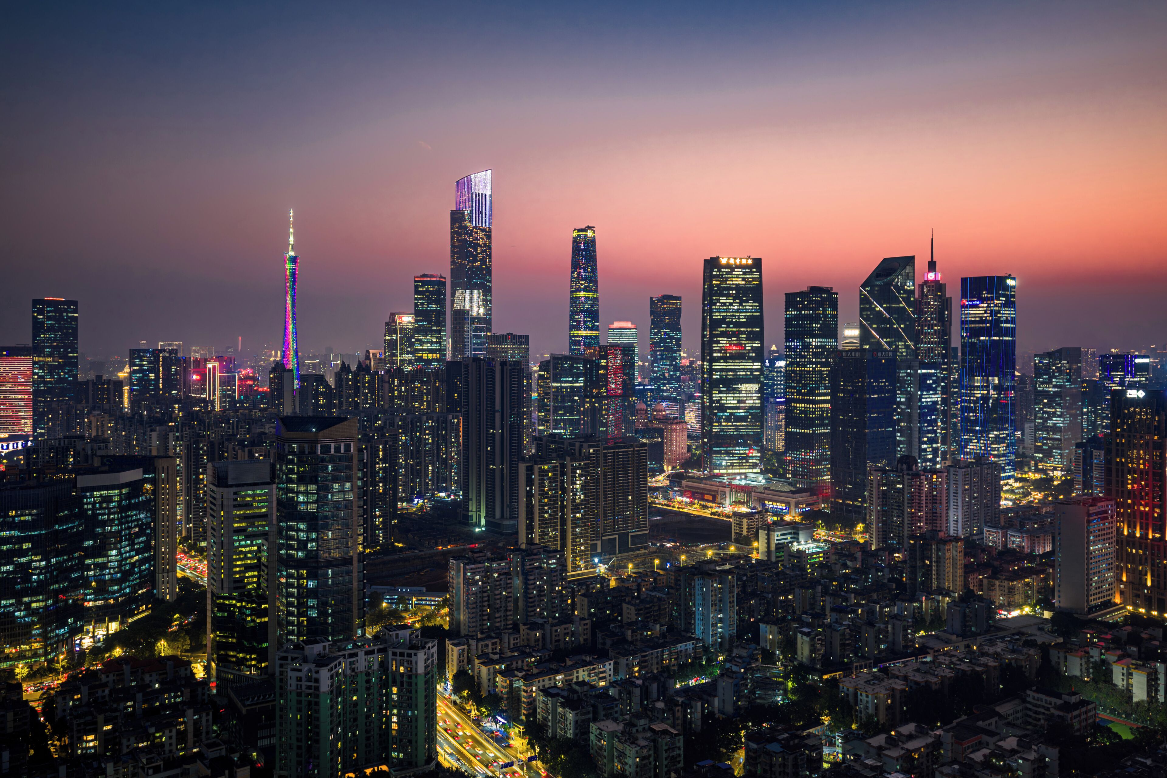 A cityscape with high-rise buildings, one with a distinctive spire, and a dense urban environment.
