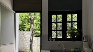 A narrow kitchen with a window overlooking a garden.