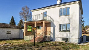 A two-story building with a balcony, a staircase, and a small porch area. - 1 bedroom stunning apartment in Vimmerby (Vimmerby)