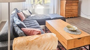 A cozy living room with a sectional sofa, a wooden coffee table, a small rug, and a dresser with drawers. - 1 bedroom stunning apartment in Vimmerby (Vimmerby)