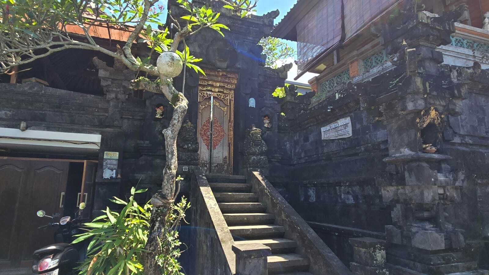 Una escalera de piedra que lleva a un edificio tradicional con intrincados adornos y un cartel que indica un museo.