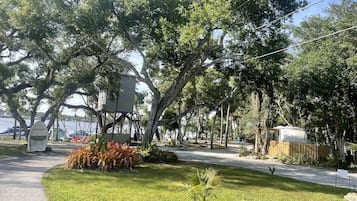 Un parc avec des arbres, un sentier et un petit bâtiment.