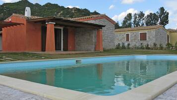 A swimming pool with a stone building in the background.