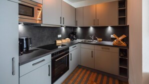 Une cuisine moderne équipée d’un four à micro-ondes, d’une cuisinière et d’une machine à café.