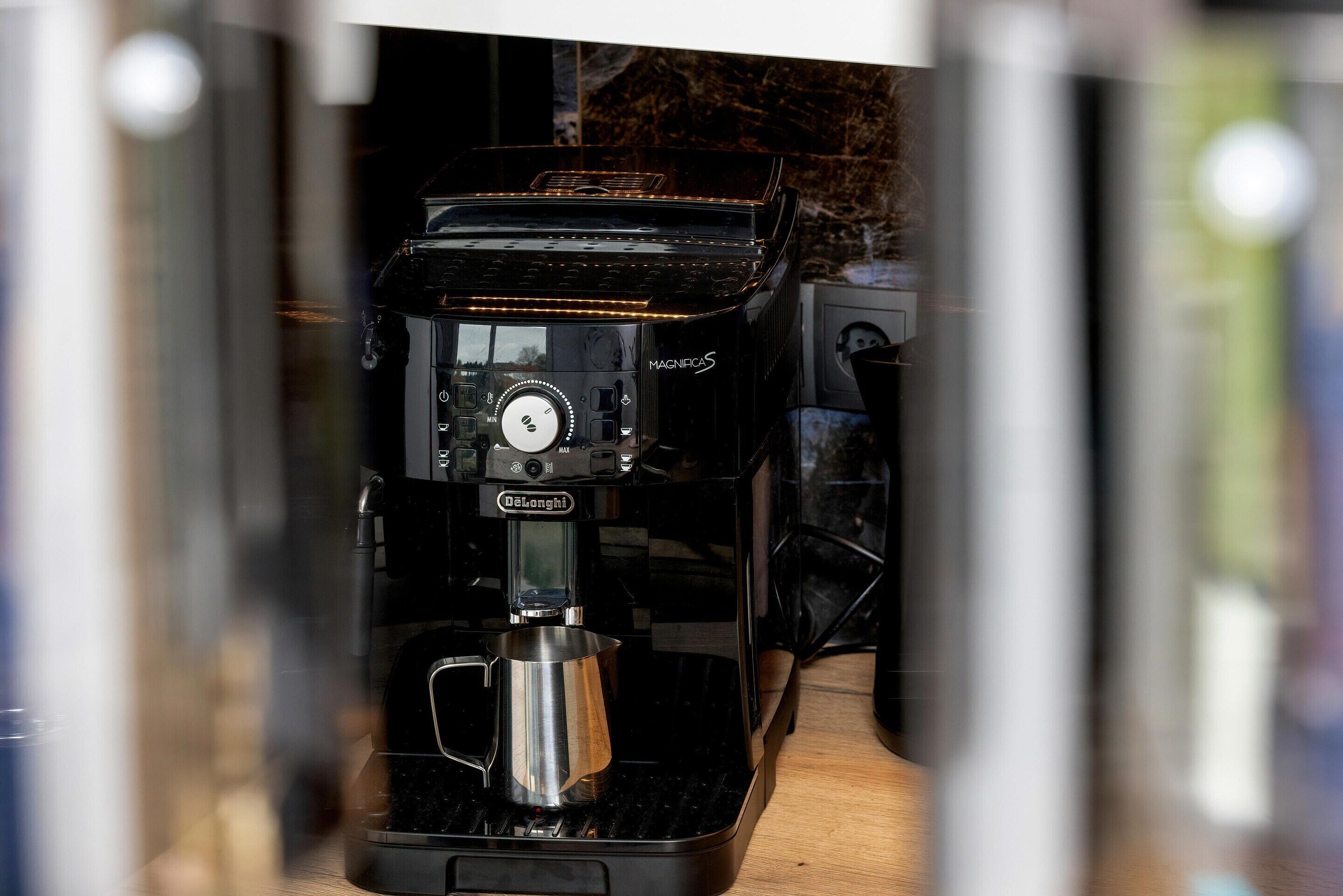 Une machine à café dotée d’un écran numérique, d’une marque et d’un panneau de commande.