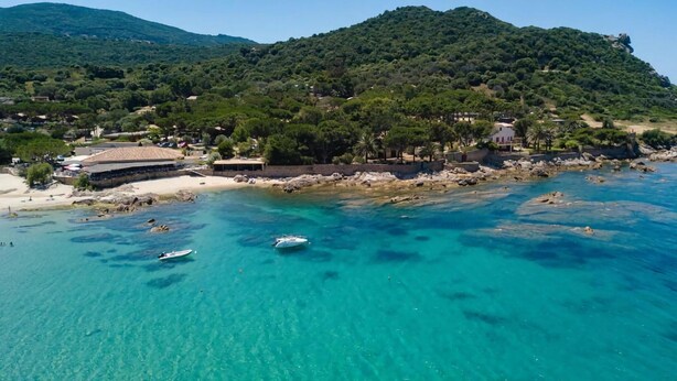 A coastal area with clear turquoise waters, boats, and a building with a roof. - Group Stay Near Sea in Propriano (Belvedere-Campomoro)