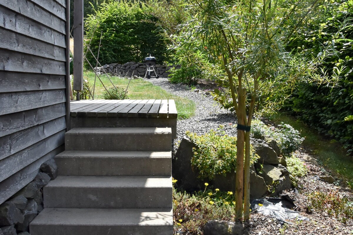 A wooden house with a stone staircase leading to a covered porch.