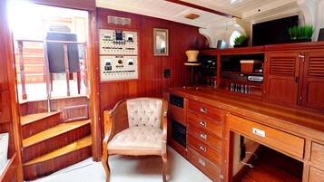 Un interior de madera con una silla, un panel de control y un armario.