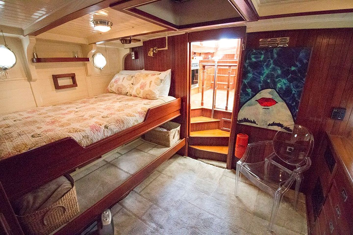 Una cabaña compacta con literas, una pequeña zona de estar y una puerta que da a un espacio exterior.