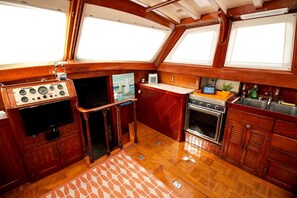Una cocina pequeña e integrada con estufa, lavamanos y un refrigerador compacto.