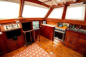 A compact galley with a stove, sink, and a small refrigerator.