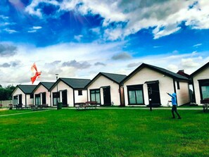 A row of single-story houses with a grassy yard in front. - Comfortable, Single-story Holiday Homes (gmina Sianów)