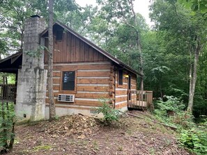 A log cabin with a chimney, a porch, and a small deck. - Enchanting Log Cabin in the Woods just Outside of Gatlinburg, Tennessee (Sevierville)