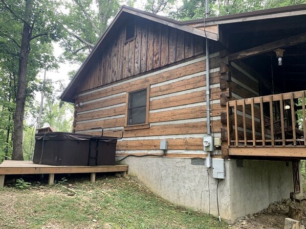 Eine Holzhütte mit Veranda, überdachter Sitzgelegenheit und Steckdose.