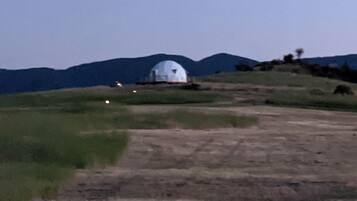 A dome-shaped building on a hill with a clear sky.