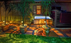 A spa area with a bathtub, two potted plants, and a wooden bench. - Quiet Cottage Rental for Two in Horse Country near Yosemite National Park Gateway, California (Catheys Valley)