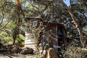 A wooden cabin surrounded by trees, with a sign reading 'WONDERLAND.' - Cozy Unique Cottage for a Peaceful Escape in Nature in Topanga, California (Topanga)