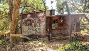 A rustic cabin with a wooden exterior, a chimney, a small porch, and a sign that reads 'Cedar Lodge.' - Cozy Unique Cottage for a Peaceful Escape in Nature in Topanga, California (Topanga)