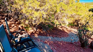 A campsite with a chair, a table, and a rocky ground with sparse vegetation.