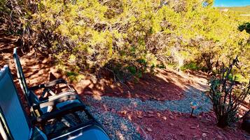 A campsite with a chair, a table, and a rocky ground with sparse vegetation.