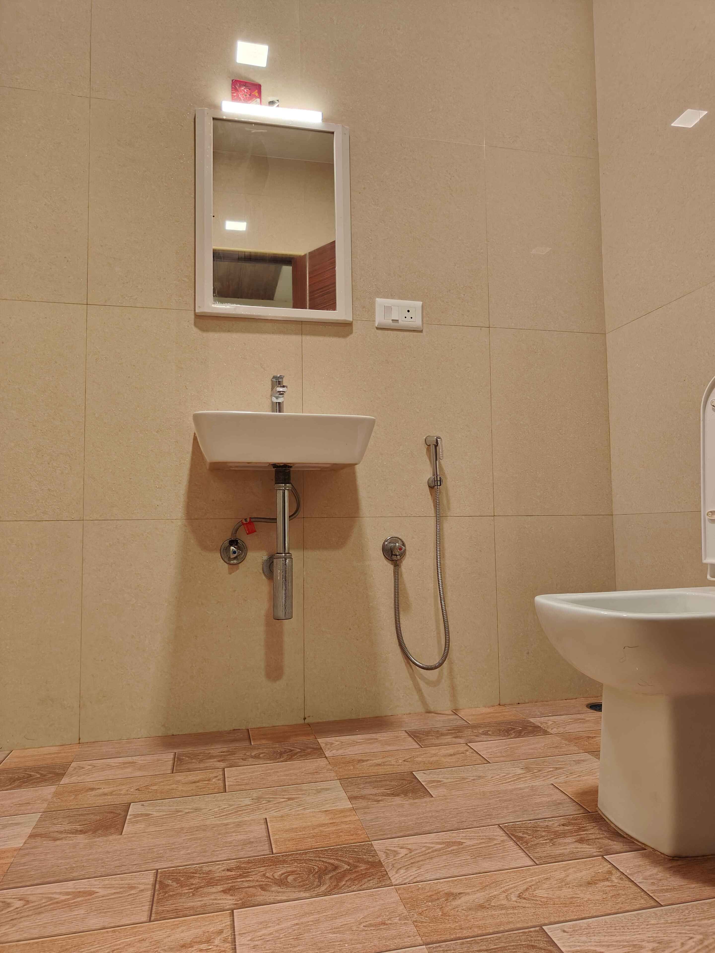 Un baño con lavamanos, espejo, ducha y retrete.