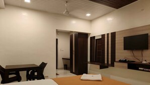 A hotel room with a bed, a desk, a chair, a TV, and a mirror. - Park Inn Beach Resort (Chennai)