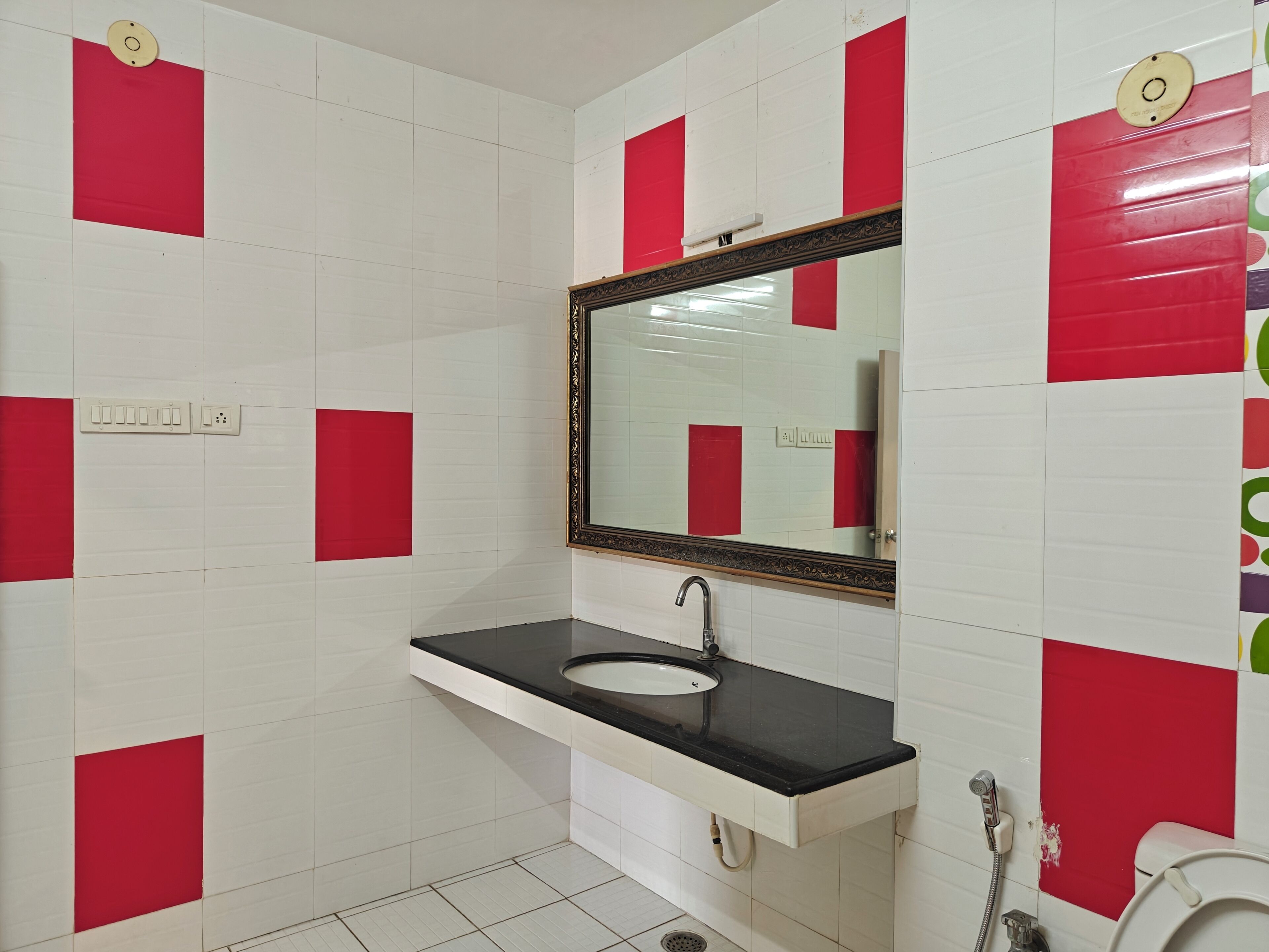 A bathroom with a sink, mirror, and toilet.