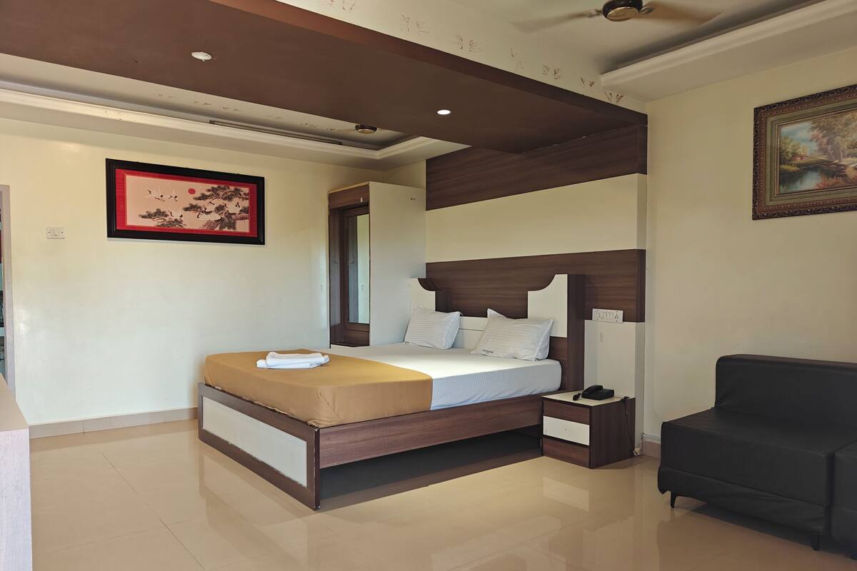A bedroom with a bed, bedside table, and a chair.