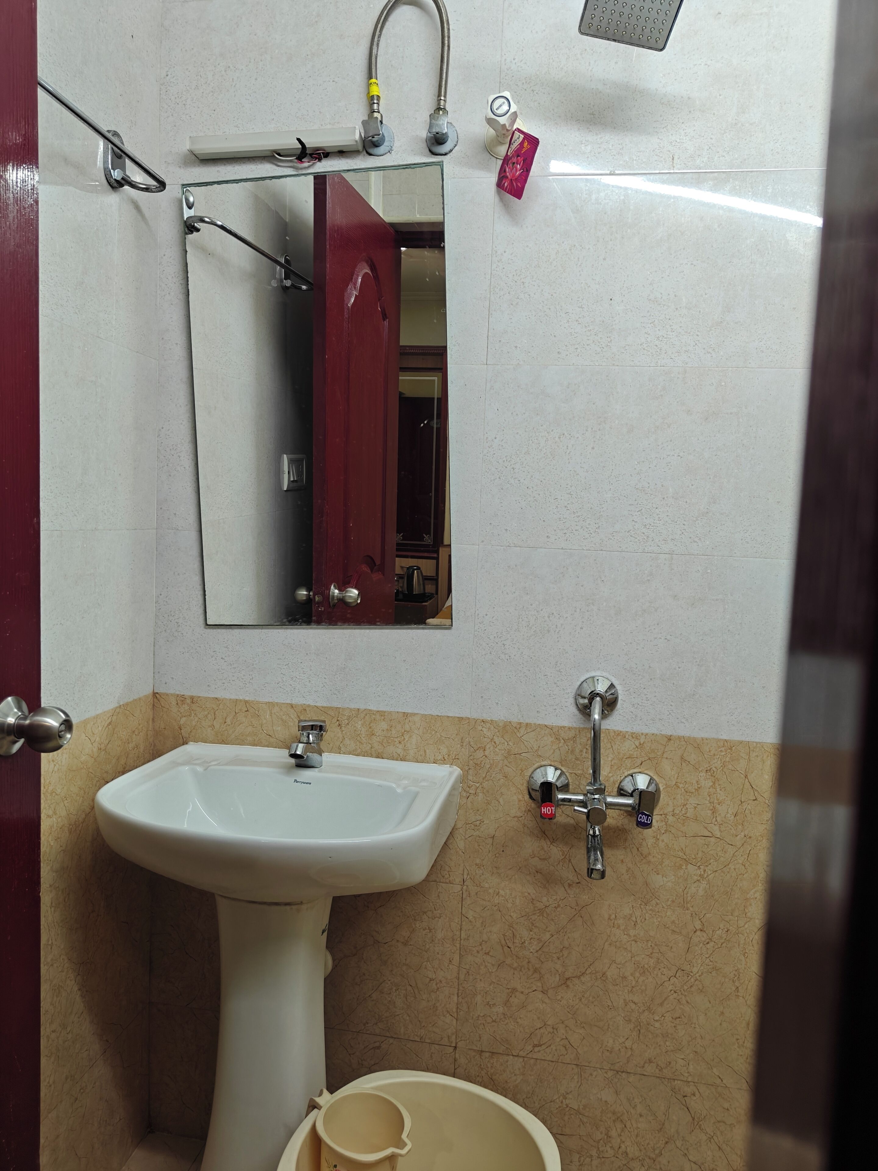 A bathroom with a white sink, a mirror, a towel rack, and a shower.