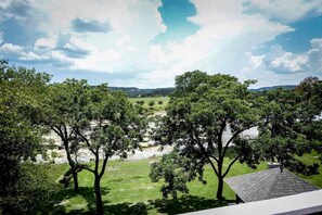 A view of a river with trees and a distant landscape. - Riverfront Cabin with Spacious Interior, Large Deck and Views in Texas (Wimberley)