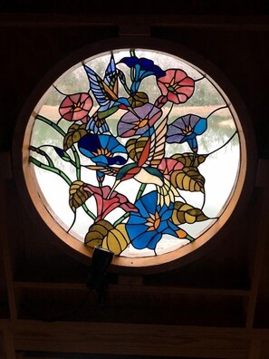 Una ventana circular con vidrieras de motivos florales.