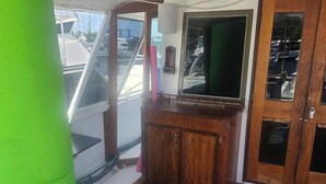 A wooden deck with a small wooden cabinet and a window. - Hatteras Sleeps 8 & SelfDrive 20' Pontoon Fishing Lobstering Snorkeling Sandbar (Key West)