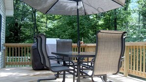 An outdoor patio with a table and chairs, an umbrella, and a grill. - Lovely Cottage Getaway in the Mountains near Phoenicia, New York (Chichester)
