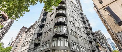 Ein mehrstöckiges Gebäude mit einem markanten 'EXCELSIOR'-Schild, das einen modernen architektonischen Stil mit Balkonen und großen Fenstern aufweist.