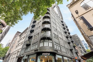A multi-story building with a prominent 'EXCELSIOR' sign, featuring a modern architectural style with balconies and large windows. - Luxury Villas The Lane Hideaway (Melbourne)