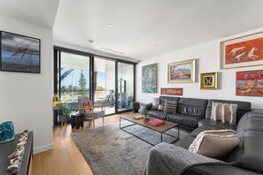 Ein modernes Wohnzimmer mit einer Couch, einem Couchtisch und Kunstwerken an den Wänden.