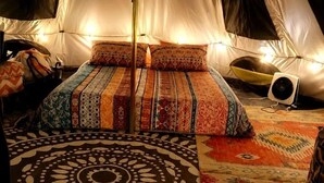 A tent with a bed, a fan, and patterned rugs. - Off-Grid Creekside Tent Ideal for a Glamping Experience in Cosby, Tennessee (Cosby)