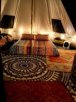A tent with a bed, a fan, and patterned rugs. - Off-Grid Creekside Tent Ideal for a Glamping Experience in Cosby, Tennessee (Cosby)