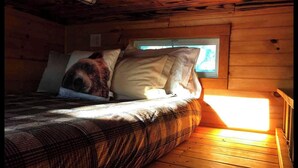 A wooden cabin bedroom with a bed, pillows, and a window. - Unique Wooden Tennessee Cabin near Knoxville for Relaxing Great Smoky Vacations (Newport)