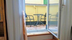 Une pièce dotée d’un escalier en bois menant à un balcon agrémenté d’une table et de chaises.