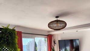 Una sala de estar moderna con sofá, televisión y vistas al exterior.