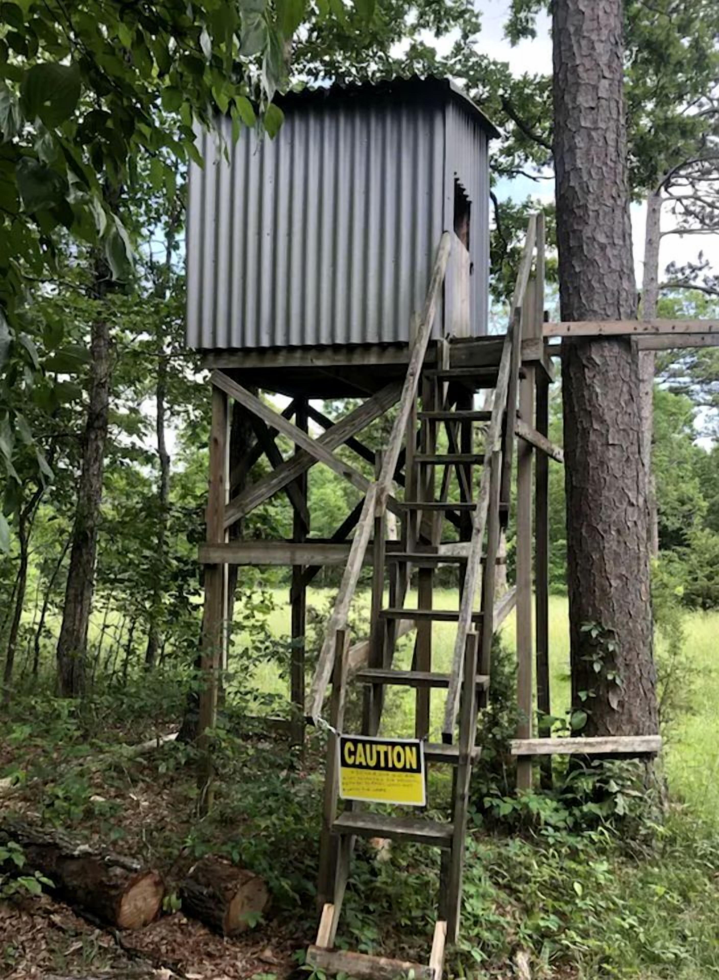 A metal structure with a wooden staircase and a caution sign.