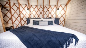 Une chambre à coucher avec un lit, des murs en bois et un plafond à treillis.