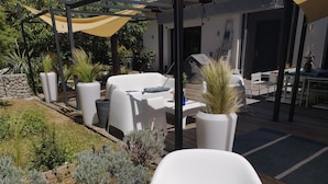 Un’area patio con arredi da esterno, piante in vaso e un rivestimento in legno.