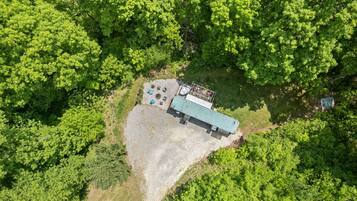 An aerial view of a building surrounded by dense green forest.
