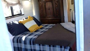 A bedroom with a bed, a wardrobe, and a window.