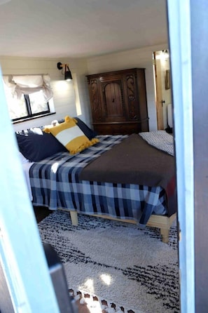 A bedroom with a bed, a wardrobe, and a window.