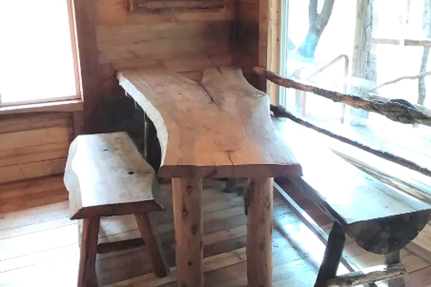 A rustic wooden interior with a bench and a table.